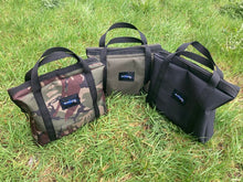 Load image into Gallery viewer, Three Midwater Grill Pan Bags on the grass showing the three colours from left to right of DPM Military Olive and Stealth Black.