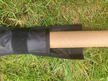 Load image into Gallery viewer, Midwater Pole Sleeve on the grass with the top open and a cardboard tube demonstrating the width of the opening