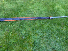 Load image into Gallery viewer, Midwater Pole Sleeve in black and mad orange colour on the grass with a recognisable pole in position