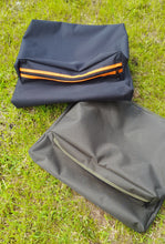 Load image into Gallery viewer, Midwater Chair Tidy in black and mad orange and one also lay on the grass in olive green