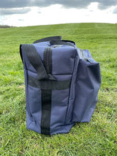 Load image into Gallery viewer, A large competition blue Midwater Carryall with carry handles and a shoulder strap, showing side view, placed on a grassy field.